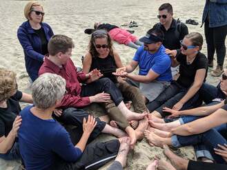  Jelica Nuccio, John Lee Clark, Oscar Chacon, sit in a circle with many interpreters on the beach, as they demonstrate a new concept in Protactile language.